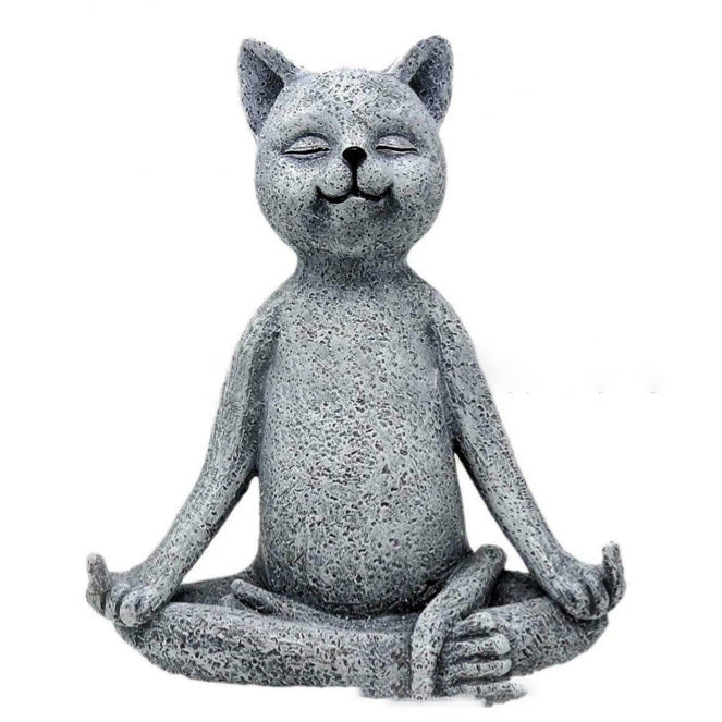 Concrete cat statue in a meditative pose on a white background